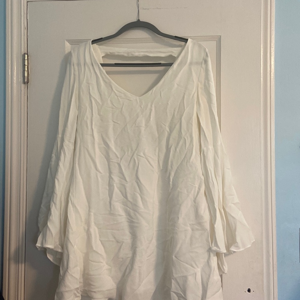 White fancy formal dress with an open back and long flowy sleeves